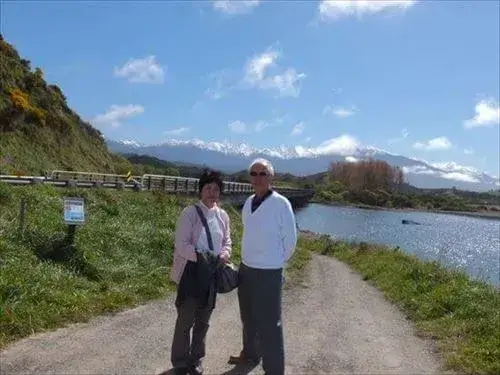 シニアホームステイの詳細はこちら~カイコウラへ行く途中 カイコウラへ行く途中の山をバックに立つシニアのご夫婦