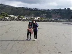 サムナビーチにて 遠浅のサムナビーチの砂浜でピースをしている女性と子ども